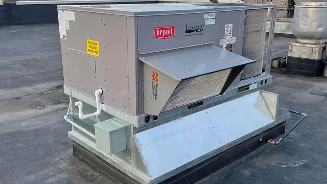 Bryant rooftop unit with its outdoor air hood on a flat commercial roof